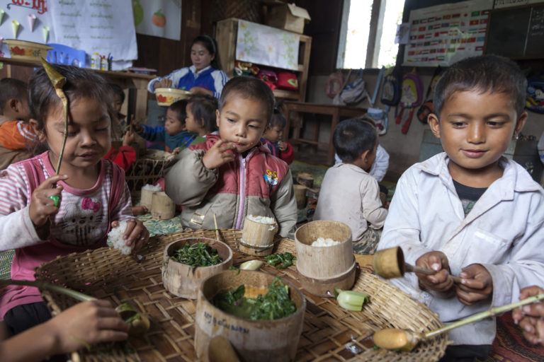 Volunteers from the community cook traditional Lao recipes with more nutritious ingredients to ensure that the children eat healthier meals. Lao PDR. Photo: Bart Verweij / World Bank